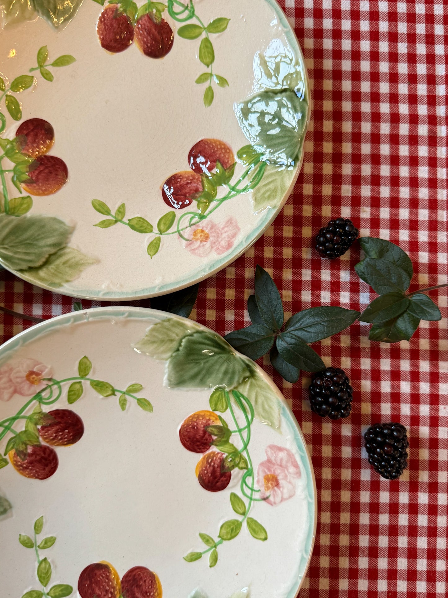 Suite de quatre assiettes en barbotine à décor de fraises